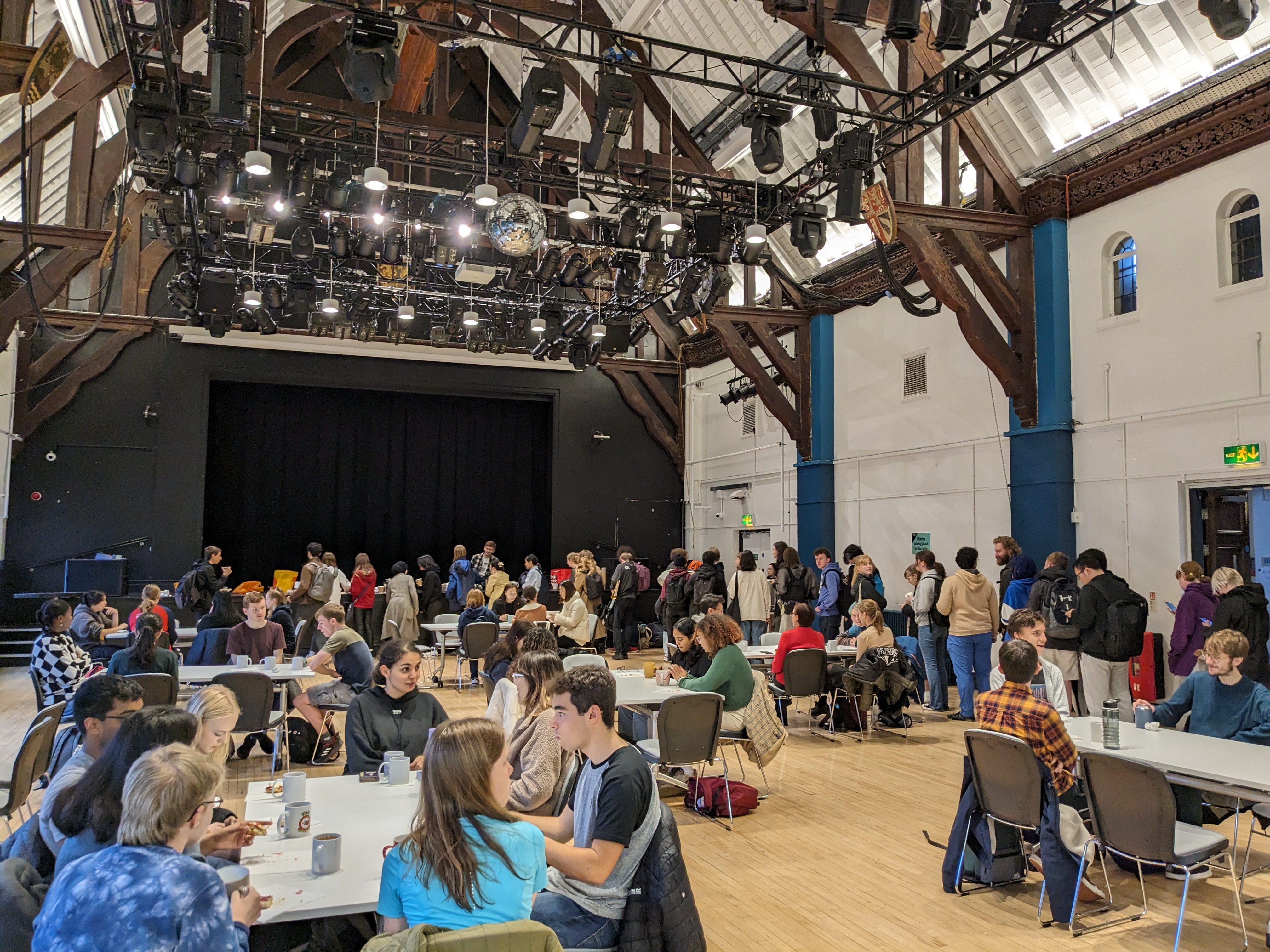 A photo from the Cream Tea event with TeaSoc. Students are lined up at the back, whilst some are sat at tables, enjoying tea or scones.